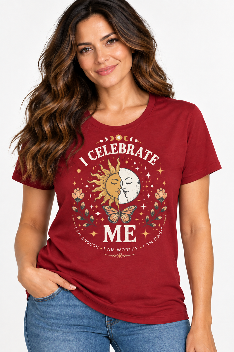 A woman wearing a red graphic t-shirt with a celestial sun and moon design and the text 'I CELEBRATE ME'.
