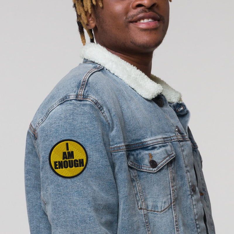 Urban young man wearing a fleece lined jean jacket with an I AM ENOUGH - Embroidered Iron On Patch on the sleeve